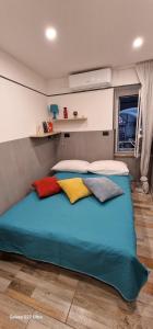 un letto in una camera con cuscini colorati di Blumon guest House a Napoli