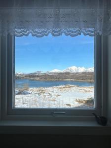 a window with a view of snow covered mountains at Nordlandshus Lofoten in Berg