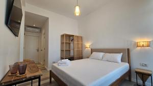 a bedroom with a bed and a table and a television at Pension Nina in Douăzeci şi Trei August