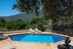 a swimming pool with two lounge chairs next to it at Hotel Blaumar Cadaqués by Fimedhotels in Cadaqués