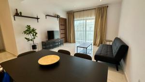 San ĠwannにあるPauliz Apartmentsのテーブルとソファのあるリビングルーム