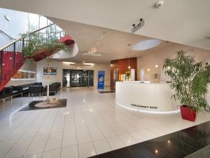 an office lobby with a reception desk and potted plants at EA Hotel Tereziánský dvůr in Hradec Králové