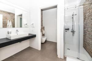 a white bathroom with a sink and a shower at Rise Urban Art Hotel in Larnaca