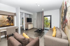 a living room with two couches and a kitchen at Rise Urban Art Hotel in Larnaca