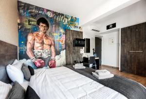 a bedroom with a king sized bed with a boxing mural at Rise Urban Art Hotel in Larnaca