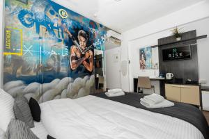 a bedroom with a large bed and a wall with a mural at Rise Urban Art Hotel in Larnaca