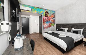 a bedroom with a large bed with a large painting on the wall at Rise Urban Art Hotel in Larnaca