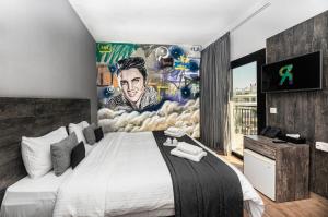a bedroom with a large bed with a painting on the wall at Rise Urban Art Hotel in Larnaca