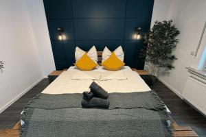 a bedroom with a large bed with yellow pillows at Geräumiges Apartment mit XXL Leinwand I Parkplatz I WiFi in Bochum