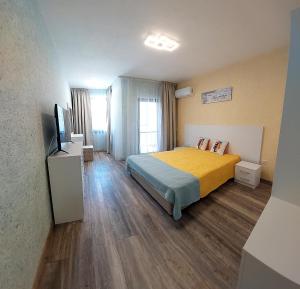 a hotel room with a bed and a television at Art Sense Мезонет in Shkorpilovtsi