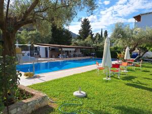 a yard with a pool and a table with an umbrella at Horizon studio apartment in Palaiokatoúna