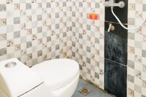 une salle de bain avec toilettes et un mur carrelé dans l'établissement RedDoorz Syariah at Shakira Alesha Enggal, à Bandar Lampung