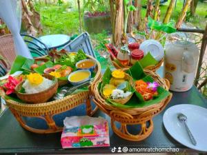 a table with two baskets of food on it at Alaska pool cafe&homestay2 in Ban Ton Pho