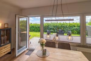 a dining room with a table with a vase of flowers at Deichblick No1 in Krummhörn