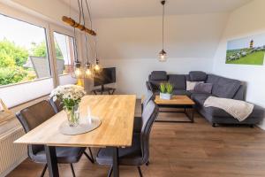 a living room with a table and chairs and a couch at Deichblick No1 in Krummhörn +27 photos