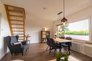 a dining room with a table and chairs and a window at Deichblick No1 in Krummhörn