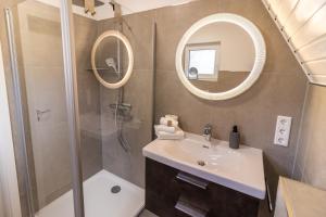 a bathroom with a sink and a shower and a mirror at Deichblick No1 in Krummhörn