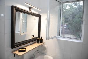 a bathroom with a mirror and a sink at Chic & Calm apartment 3 minutes walk to Rafina Beach in Rafina +32 photos