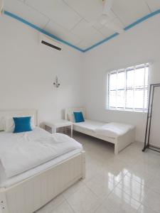 a white room with two beds and two windows at 1267 Afamosa Private Pool Durian In The House in Kampong Ayer Hitam +91 photos