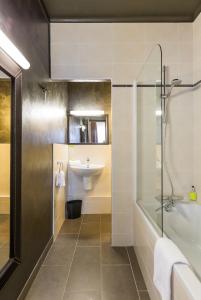 a bathroom with a shower, sink, and mirror at Hotel Ajoncs d'Or in Saint Malo