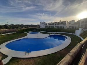 ein großer blauer Pool in einem Hof mit Häusern in der Unterkunft La casa de la encina in El Ronquillo