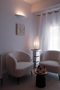 two chairs and a table in a living room at The White Knight Premium Boutique Hotel in Għajnsielem