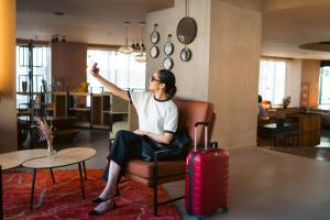 une femme assise dans une chaise avec une valise dans l'établissement Kaan Casablanca, à Casablanca