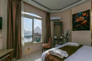 una camera d'albergo con un letto e una finestra di Horizon Pyramids View inn a Il Cairo Altre 37 foto