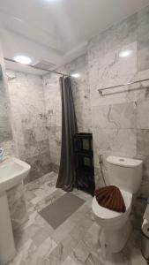 a bathroom with a toilet and a sink and a shower at Rawai Beach Condo by Holy Cow in Nai Harn Beach