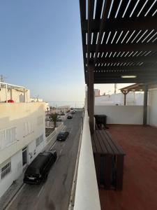 a balcony with a bench and a car on a street at Casa familiar en la almadraba con espectacular terraza in El Pozo del Cabo