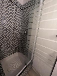 una doccia con una porta in vetro in un bagno di Maison de vacances avec jardin, 650m de la mer, WIFI,CLIM a Saint-Cyprien Altre 2 foto