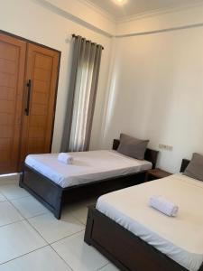 2 camas en una habitación con puerta en Bale sunrise, en Gili Trawangan