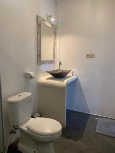 y baño con aseo y lavabo con espejo. en Bale sunrise, en Gili Trawangan
