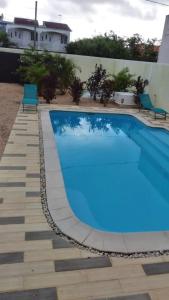 a blue swimming pool with two chairs next to a building at Idyllic Villa in Pereybere with Private Pool in Pereybere
