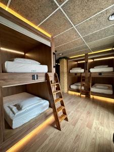 a room with three bunk beds and a ladder at The POD Suite Hostel Village in Valencia