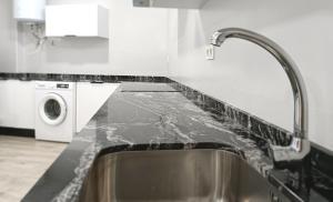 a kitchen with a sink and a washing machine at Casa Pastor in Murcia