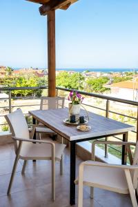 a table and chairs on a balcony with a view at House Rytha in Limenaria