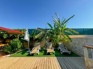 a patio with two chairs and an umbrella on a deck at Casa de Aloe in Albufeira