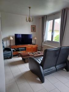 a living room with a couch and a television at Maison cosy 600m de la gare de Rambouillet in Rambouillet