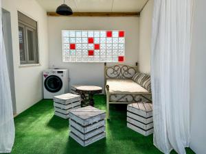 a living room with a couch and a washing machine at Casa de Aloe in Albufeira