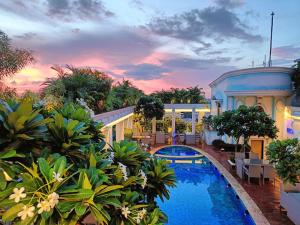 een resort met een zwembad en een gebouw bij De Sovrani in kolkata