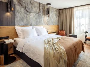 a hotel room with a bed and a desk at Nomadic Urban Premium Suites in Krakow