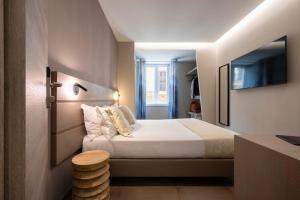 a hotel room with a bed and a television at The Point Suites Rome - Guest House in Rome +48 photos