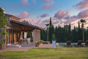 una casa con un patio con mesa y sillas en Villa Can Figuera, en Alcudia