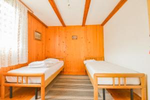 zwei Betten in einem Zimmer mit Holzwänden in der Unterkunft Villa Miris Prirode Zenik in Ilidža + 25 Fotos