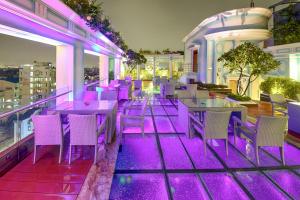een restaurant met paarse verlichting op het dak van een gebouw bij De Sovrani in kolkata