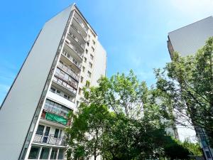 a tall white building with trees in front of it at Apartament Złota Piaskowa in Wałbrzych