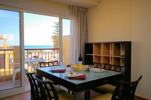 a dining room with a table and chairs and a balcony at Apartamento Belvedere - Deniasol in Denia