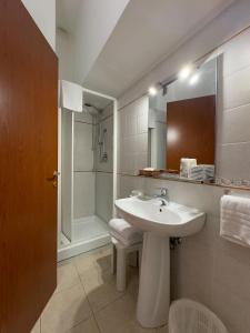 a white bathroom with a sink and a shower at Hotel Villa Robinia in Genzano di Roma