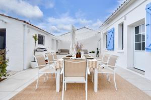 a dining room with a table and chairs on a patio at Coup de coeur - 200m plage - 6 adultes - 4 enfants in Le Grand Vieil